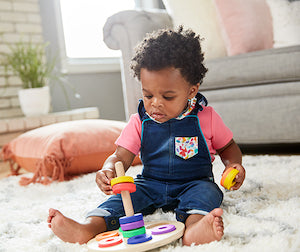 child trying to fit colorful stacking rings